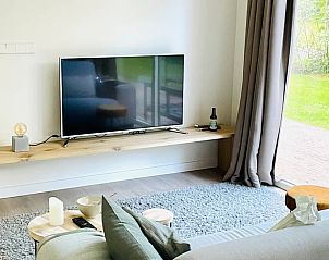 Gezellige woonkamer met televisie in Vakantiehuisje in Oosterwolde, perfect voor ontspanning.