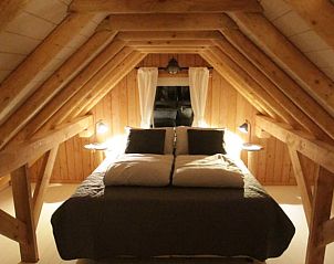 Knusse slaapkamer met houten balken in Huisje in Haulerwijk, vakantiehuis in de Friese bossen.