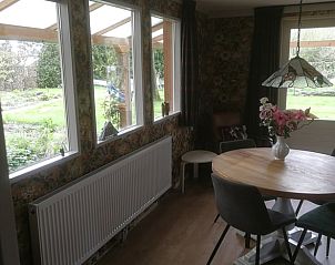 Eethoek in Vakantiehuisje in Haulerwijk, met uitzicht op de groene tuin in de Friese bossen van Friesland.