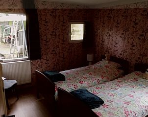 Slaapkamer met twee bedden in Vakantiehuisje in Haulerwijk, gelegen in de rustieke omgeving van Friesland.