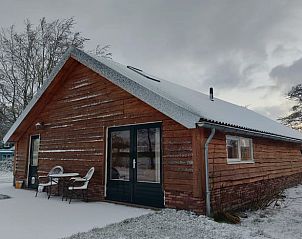 Sneeuw bedekt Vakantiehuis in Haulerwijk, een winterwonderland in Friesland.