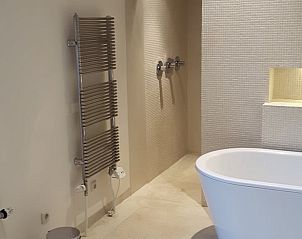 Moderne badkamer met bad in Huisje in Boijl, vakantiehuis in Friesland.