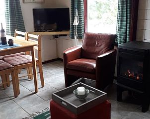 Knusse woonkamer met haard in Huisje in Boijl, Friesland.