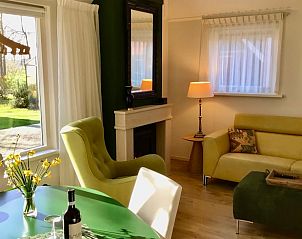 Gezellige woonkamer van Vakantiehuis in Boijl, met uitzicht op de groene omgeving in de Friese bossen, Friesland.