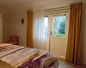 Slaapkamer met toegang tot de tuin in Vakantiehuis in Boijl, gelegen in de Friese bossen van Friesland.