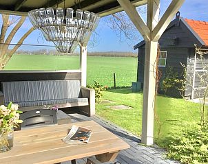 Veranda met uitzicht op groene velden bij Vakantiehuis in Boijl, gelegen in de Friese bossen van Friesland.