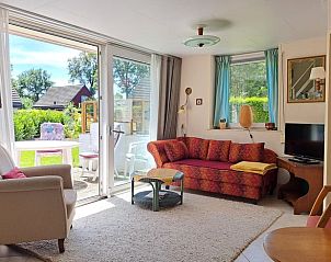 Zonnige woonkamer met grote ramen in Vakantiehuis in Boijl, uitzicht op de tuin.