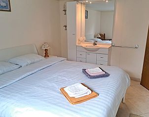 Ruime slaapkamer in Vakantiehuis in Boijl, Friesland met spiegel en nachtkastjes.