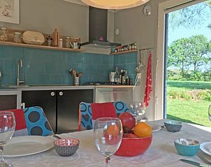 Eettafel in vakantiehuis in Boijl, Friesland met uitzicht op groene tuin.