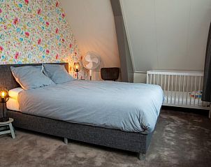 Ruime slaapkamer met babybed in Vakantiehuis in Hoornsterzwaag, Friese bossen.