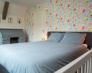 Sfeervolle slaapkamer met kleurrijk behang in Vakantiehuis in Hoornsterzwaag, Friesland.