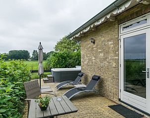 Veranda van Huisje in Allingawier met ligstoelen en uitzicht op Friese bossen in Friesland.