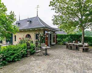 Buitenterras van Huisje in Allingawier omringd door groene tuinen in de Friese bossen.