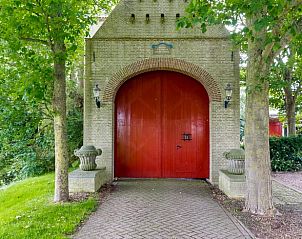Rode deur van Vakantiehuis in Allingawier, met uitzicht op Friese bossen.