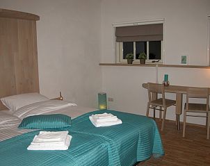 Sfeervolle slaapkamer in vakantiehuis De Turfhoeke, Gorredijk, omgeven door Friese bossen in Friesland, met comfortabel bed en bureau.