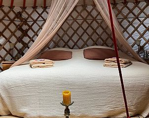 Knus bed met klamboe in de yurt van Vakantiehuisje in Ravenswoud, Friesland.