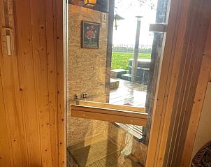 Saunadeur met uitzicht op landschap in Vakantiehuisje in Ravenswoud, Friesland.