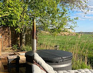 Hot tub met uitzicht op Friese natuur bij Vakantiehuisje in Ravenswoud.
