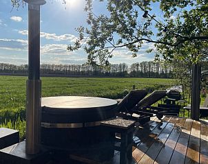 Zonnig terras met ligstoelen bij Vakantiehuisje in Ravenswoud, Friesland.