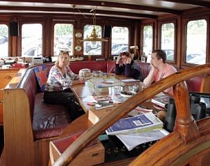Gezellige zithoek in de stuurhut van motorschip Elisabeth, gelegen in Leeuwarden, Friesland.