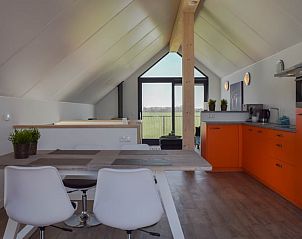 Open woonkamer in Huisje in Stavoren, Stavoren, met een moderne keuken en groot raam voor veel lichtinval.