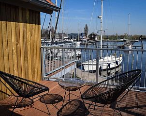 Balkon van Huisje in Stavoren, Stavoren, met uitzicht op de haven en moderne zitgelegenheid.