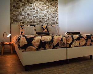 Slaapkamer in Huisje in Stavoren, Friesland, met een comfortabel bed en warme inrichting.