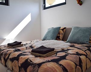 Tweede slaapkamer in Huisje in Stavoren, Friesland, met een knus bed en veel natuurlijk licht.