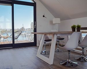 Eetruimte in Huisje in Stavoren, Stavoren, met moderne stoelen en uitzicht op de jachthaven.
