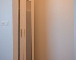 Sfeervolle hoek in Huisje in Stavoren, vakantiehuis in Friesland, met een handige kledingkast voor een opgeruimd verblijf.