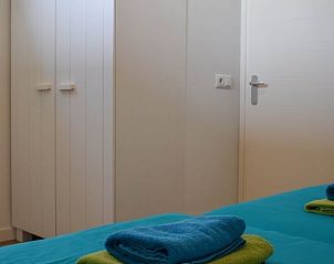 Ruime slaapkamer in Huisje in Stavoren, een vakantiehuis in Friesland, met praktische opbergruimte en fris beddengoed.