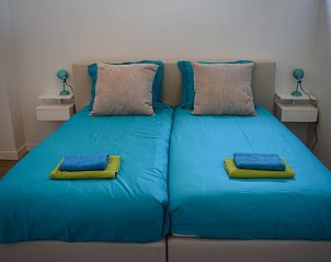 Gezellige slaapkamer in Huisje in Stavoren, een vakantiehuis in Friesland, met comfortabele bedden en sfeervolle verlichting.