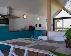 Stijlvolle keuken en eetgedeelte in Huisje in Stavoren, een vakantiehuis in Friesland, met moderne voorzieningen en uitzicht.