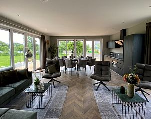 Ruime woonkamer in Chalet in Hindeloopen met moderne inrichting en grote ramen.