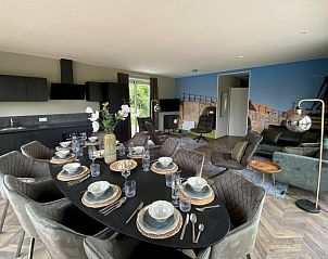 Eetkamer in Chalet in Hindeloopen, Friesland met elegant gedekte tafel en moderne keuken.