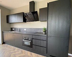 Strakke keuken in Chalet in Hindeloopen, Friesland met moderne apparatuur en veel opbergruimte.