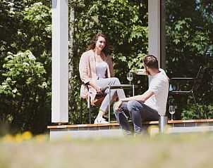 Koppel geniet van drankje op het terras van Vakantiehuis in Dokkum.