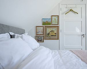 Gezellige slaapkamer met kunst aan de muur in Huisje in Wlterswld.