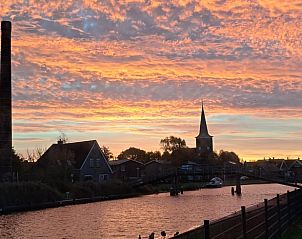 Adembenemende zonsondergang in Easterlittens met uitzicht op kanaal en kerktoren in Friesland.