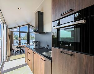 Volledig uitgeruste keuken met uitzicht in de 4-6 persoons wellness lodge in Friesland.