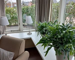 Knusse leeshoek met uitzicht op de tuin in Jorito, appartement in Brantgum, Friese platteland.