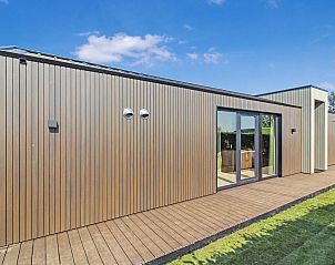 Achterzijde van vakantiehuis Oudehaske met houten gevel en terras.