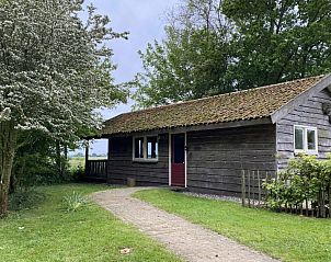Charmant exterieur van vakantiehuis Bonnehof, omgeven door groen in Westergeest, Friesland.