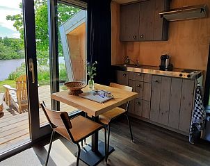 Keuken in vakantiehuisje in Westergeest met eethoek en uitzicht op het Friese platteland.