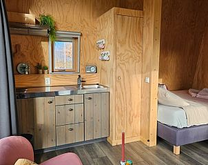 Compacte keuken en slaapgedeelte in Vakantiehuisje in Westergeest, ideaal voor een ontspannen verblijf.