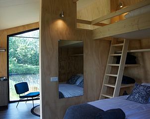 Slaapkamer in Huisje in Westergeest, vakantiehuis met comfortabele bedden en houten interieur.