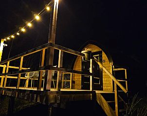 Vakantiehuisje in Westergeest sfeervol verlicht in de avond op het Friese platteland.