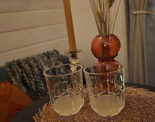 Stijlvolle binnenruimte van Vakantiehuisje in Westergeest met glazen en decoratie.