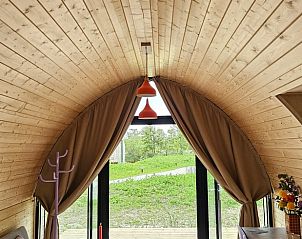 Gezellige binnenruimte van Huisje in Westergeest, met houten interieur en uitzicht op het Friese platteland.