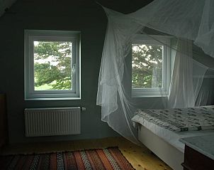Slaapkamer met hemelbed in het vakantiehuis in Scherpenzeel, ideaal voor rust en ontspanning.